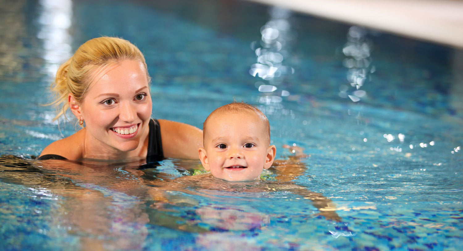Instructor teaching baby to swim